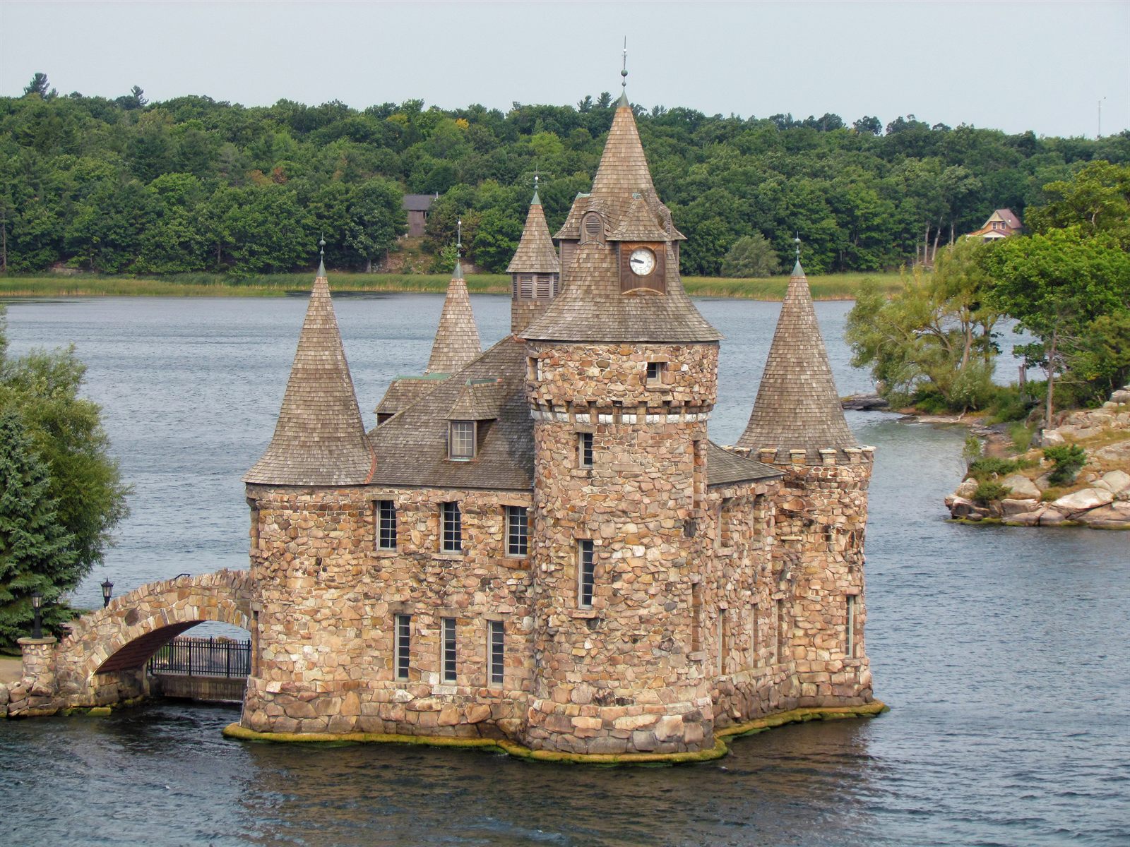 The turreted stone Power House at Boldt Castle on the St. Lawrence River, with a wooded island behind